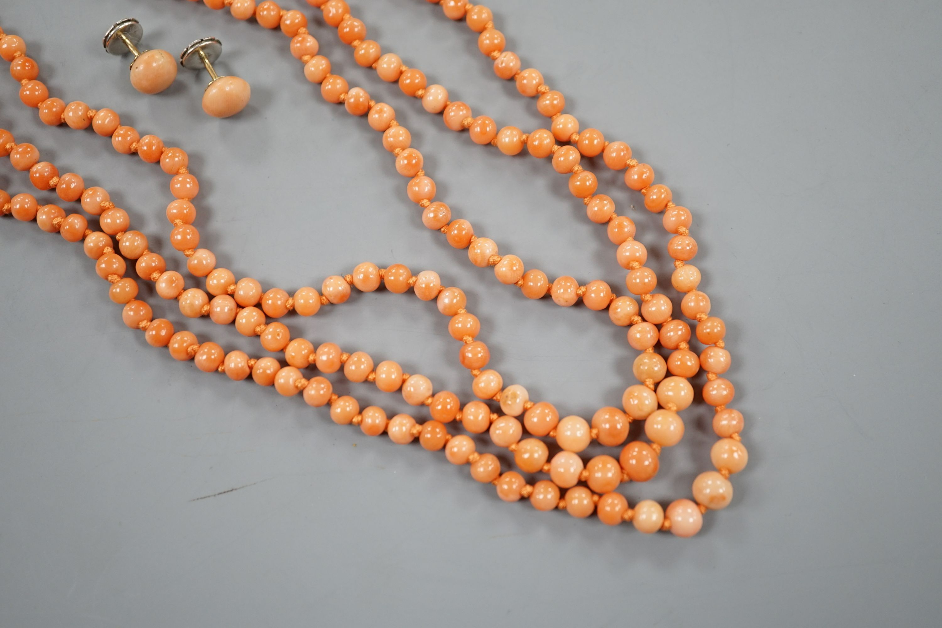 A triple strand coral bead necklace, 46cm and a pair of coral bead earrings.